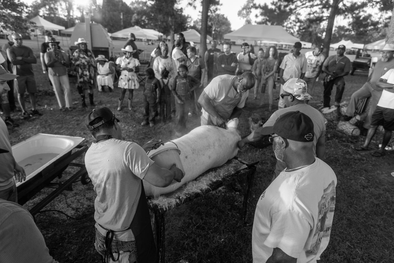 Men working a traditional boucherie as a crowd watches at Creole Culture Day 2025 in Louisiana