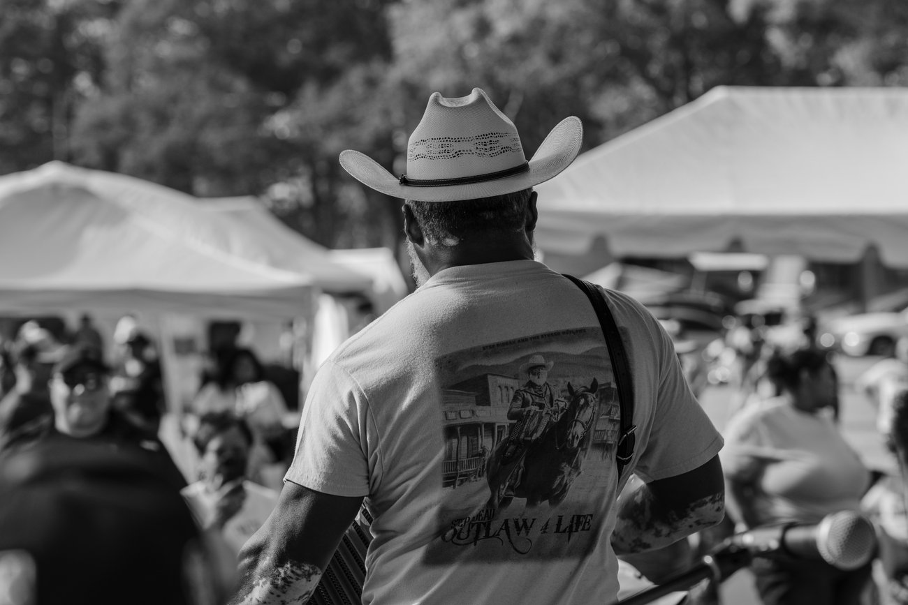 A musician in a white cowboy hat playing to the crowd at Creole Culture Day 2025 in Louisiana